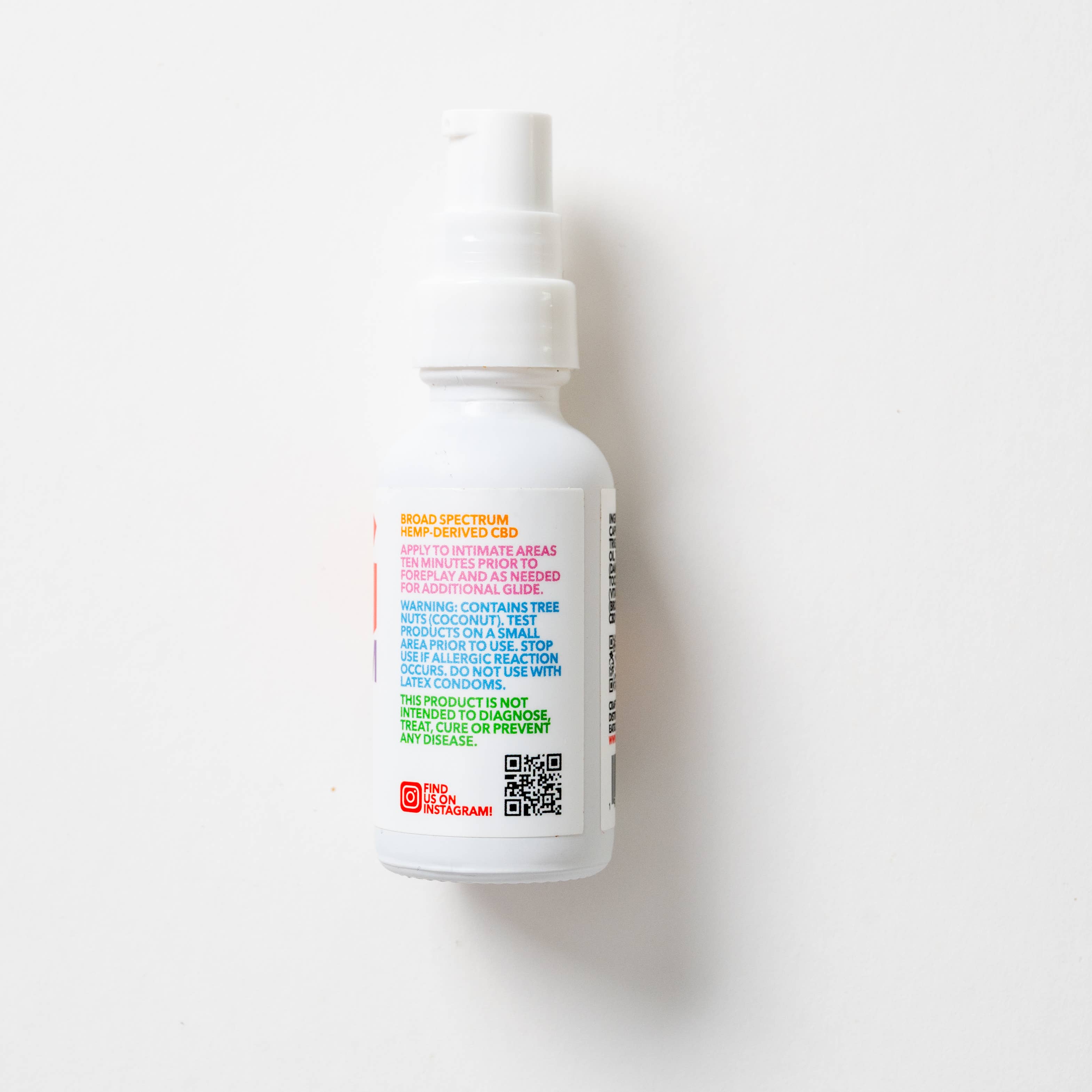 A white pump-top bottle of Eat Gold Organics’ Big Orgasm Oil is shown on a white background. The label features colorful text about damiana leaf and use, with a QR code and red Instagram icon near the bottom.