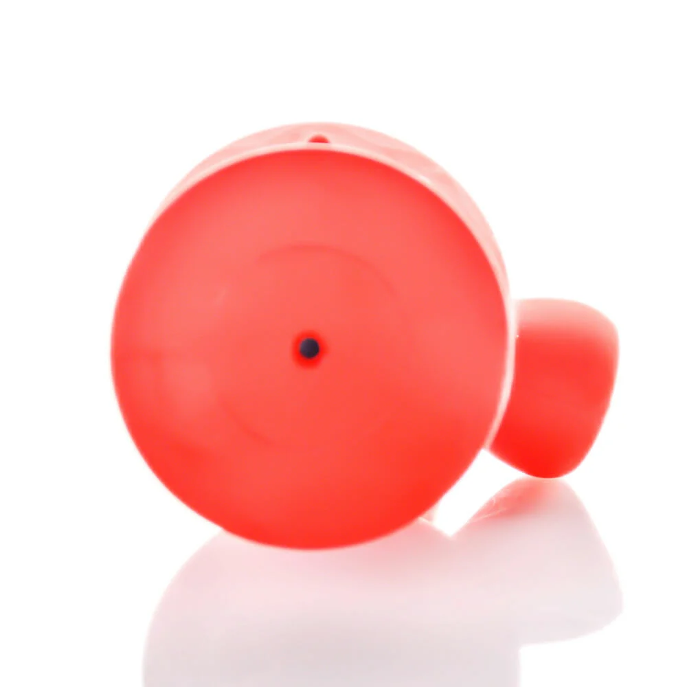 The Tug & Toke by Puff Palz is a bright red, round, natural rubber dog toy with a small black dot in the center. It appears cylindrical and hollow and is shown on a white reflective surface from a front angle.
