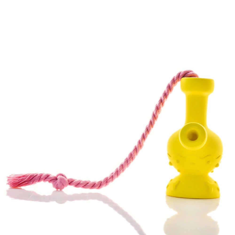 The Tug & Toke by Puff Palz is a small, bright yellow natural rubber dog toy shaped like a vase with a pink rope attached, shown on a white background.