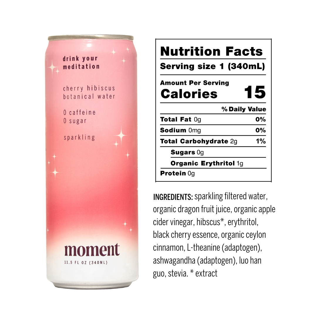 A can of Moment Botanical Beverage (cherry hibiscus flavor) from Moment is shown with nutrition facts: 15 calories, 0g fat, 2g carbs, 0g sugar. Ingredients are listed below in bold black text. The can is pink and white.