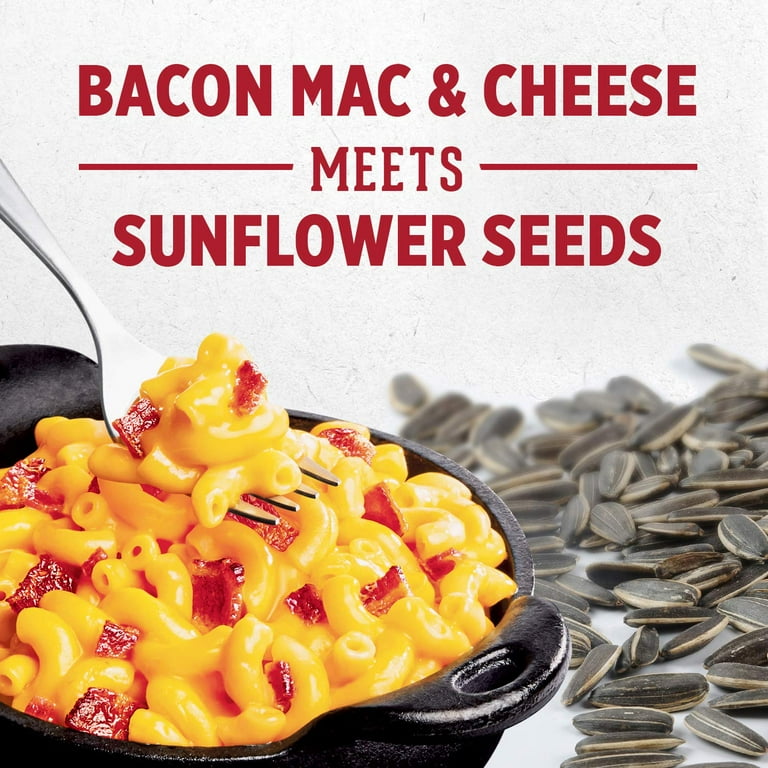 A bowl of Exotic Snacks’ David Sunflower Seeds - Bacon Mac n Cheese sits by a fork and seeds. Text: Bacon Mac & Cheese Meets Sunflower Seeds—a keto-friendly snack fusion you’ll love.