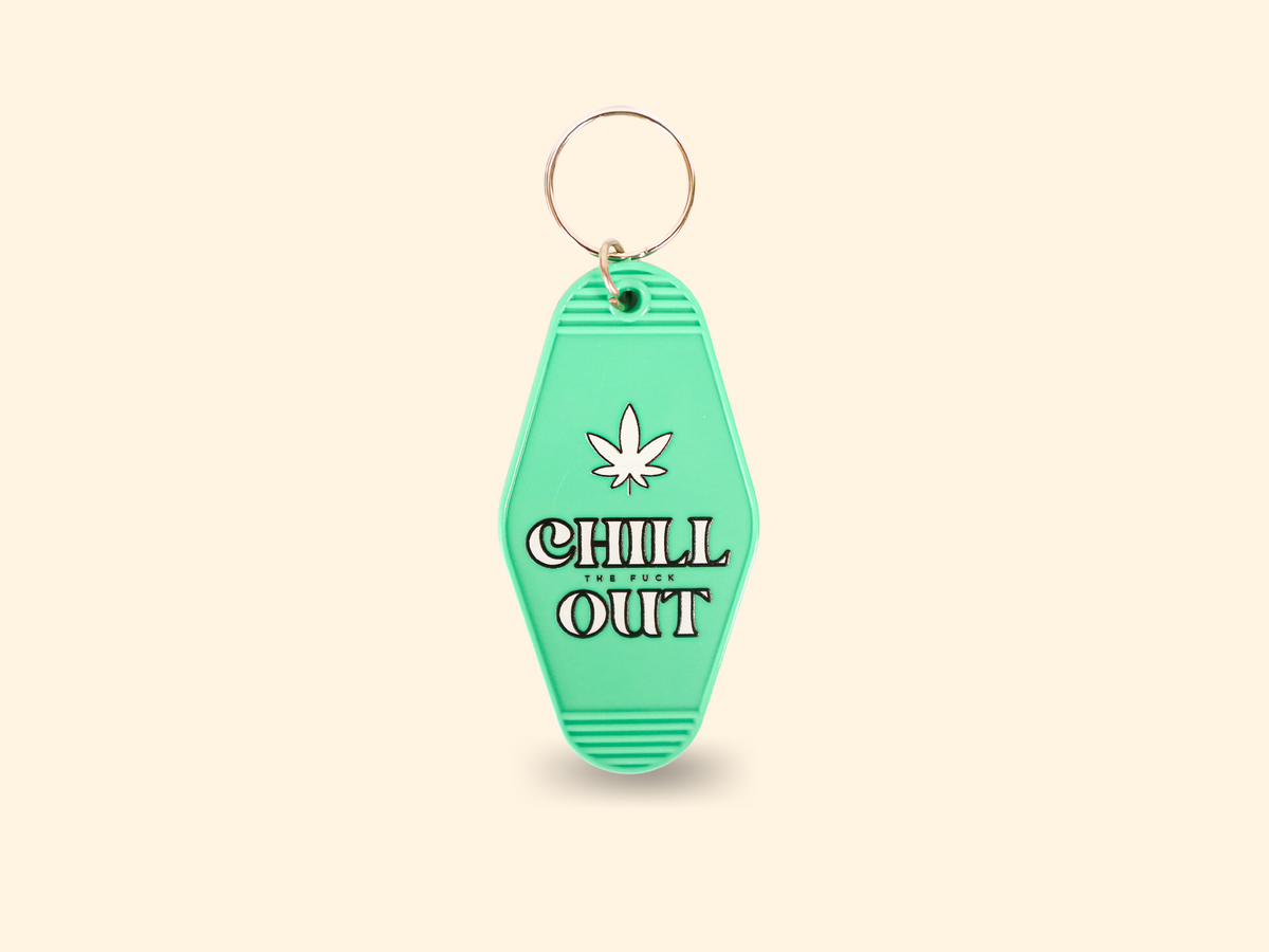 The Properly Improper Chill The Fuck Out key chain is a green, retro-style accessory with an embossed marijuana leaf and bold lettering—perfect for those who love unique keychains.