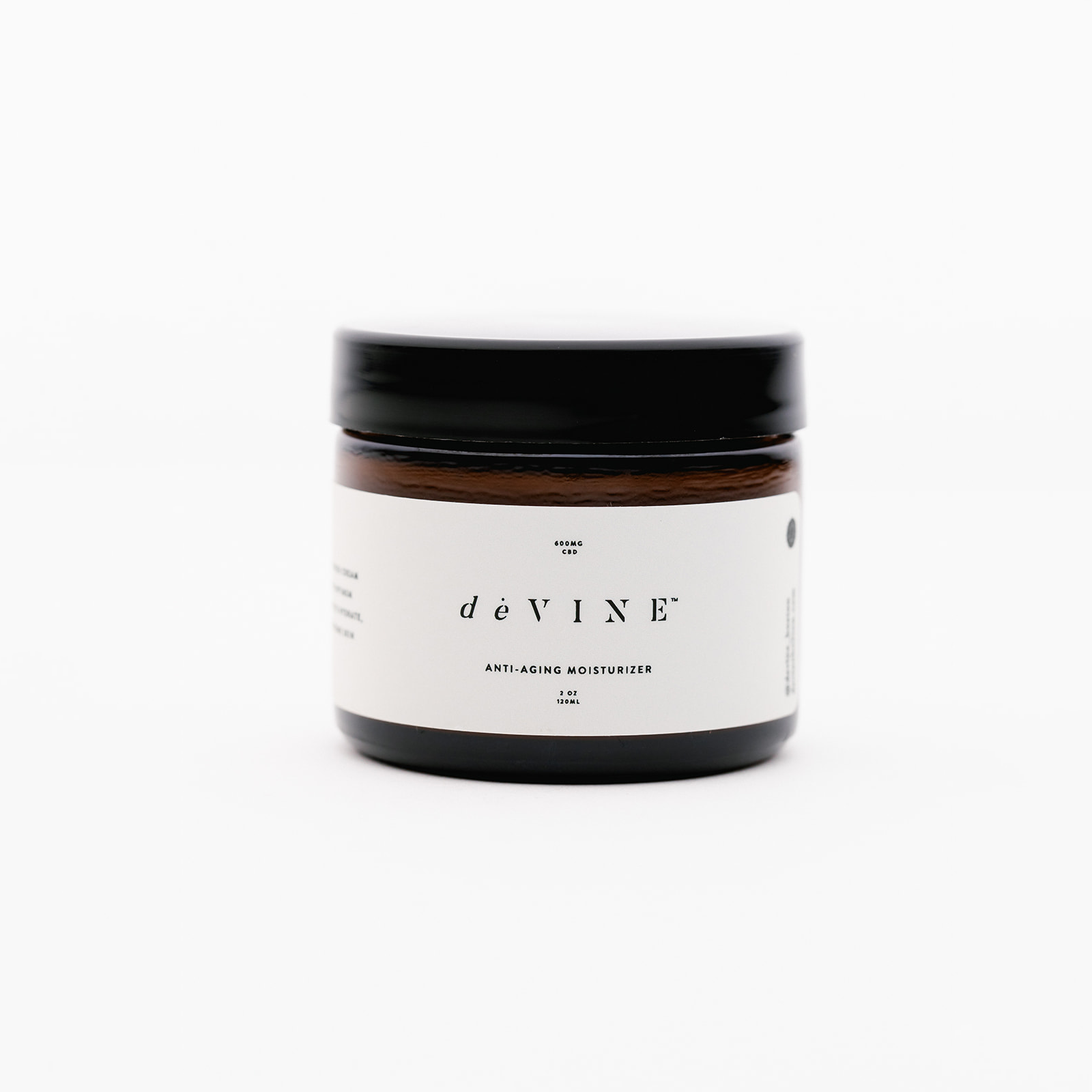 A brown glass jar with a black lid and white label displays the DeVINE Wellness brand and deVINE Anti Aging Moisturizer, spotlighting hydration benefits, set against a plain white background.