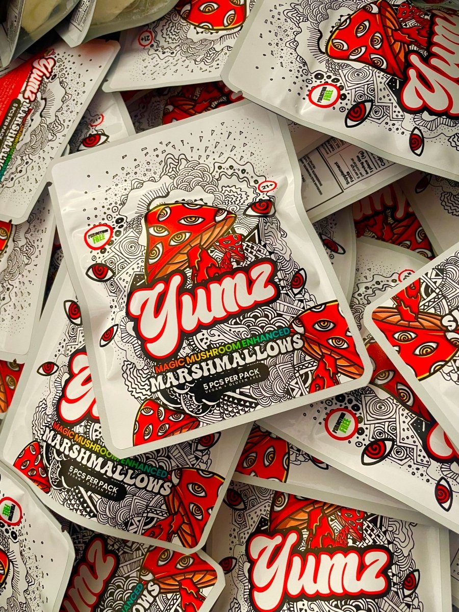 Yumz Magic Marshmallows, a playful nootropic mushroom alternative, come in packets with psychedelic designs featuring a red-eyed mushroom and detailed black-and-white patterns.