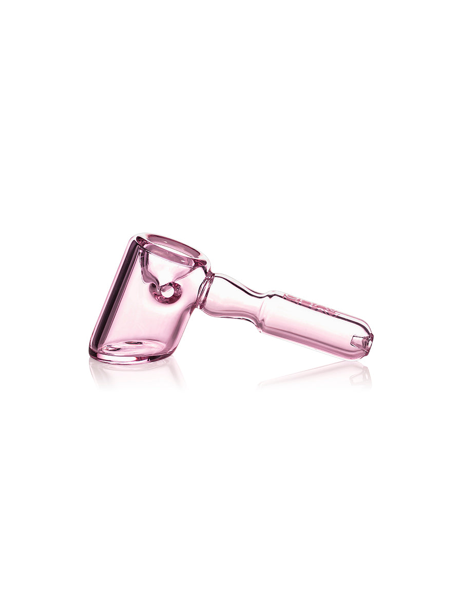The GRAV Hammer Hand Pipe, made of translucent pink glass with a cylindrical handle, large bowl, and ash catching chamber, is shown on a white background.