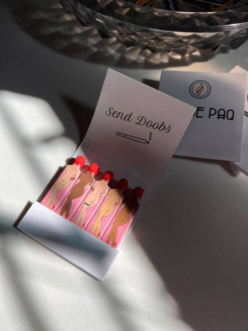 Send Doobs Matches by Rogue Paq feature weed-shaped matches illustrated as nude female forms with red tips and a playful “Send Doobs” message plus a joint drawing inside the cover—a creative cannabis accessory.